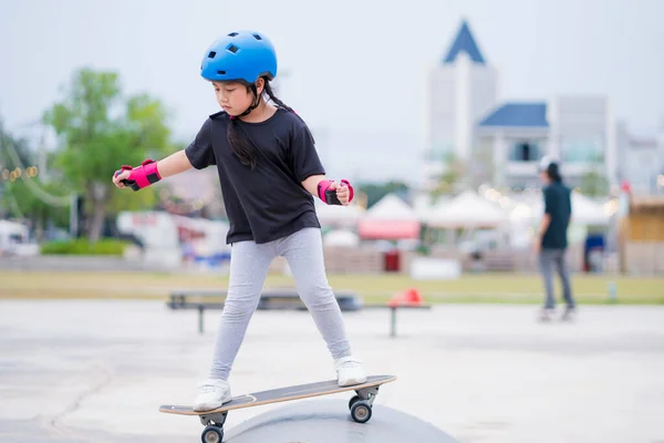 Niña aprendiendo skate con casco